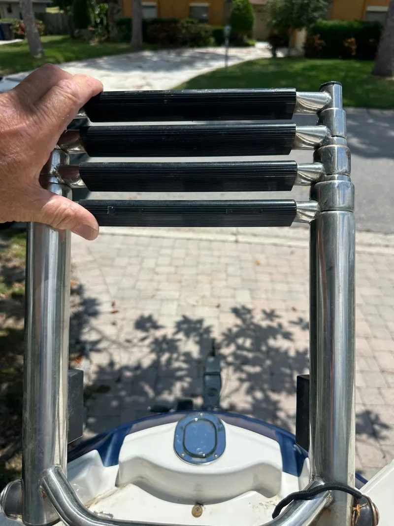 Slide: The Image of A hand holds a stainless steel ladder on a boat. - 18