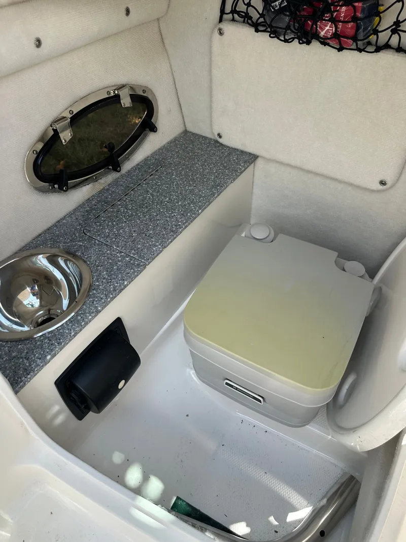 Slide: The Image of Interior of a 2017 Chaparral 243VRX with a toilet and sink. - 21