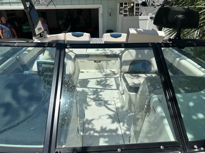 Slide: The Image of Interior view of a 2017 Chaparral 243VRX with white seating and glass cover. - 23