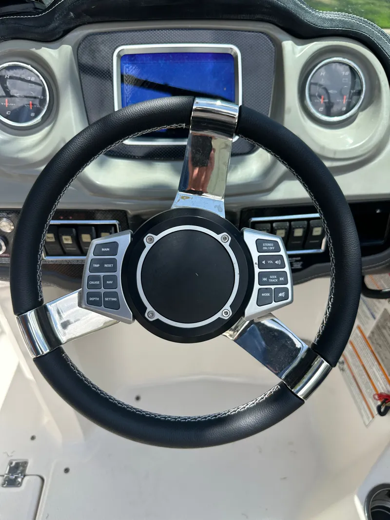 Slide: The Image of The image shows the steering wheel of a 2017 Chaparral 243VRX with modern controls. - 30