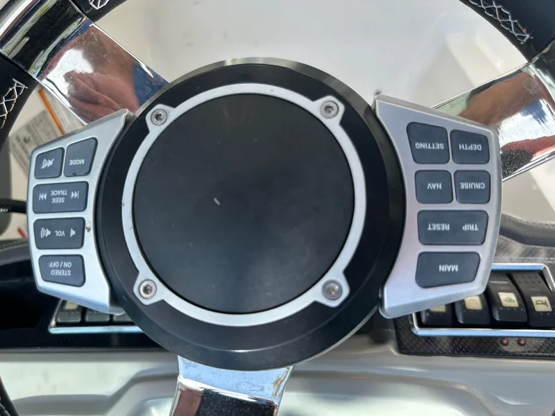 Slide: The Image of Close-up of a boat steering wheel with various control buttons. - 31