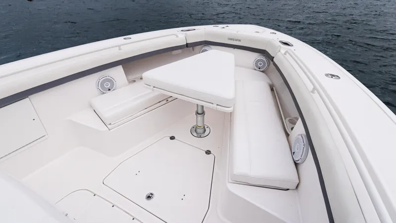 Slide: The Image of 2017 Everglades 435 CC boat interior with seating and table on calm water. - 43