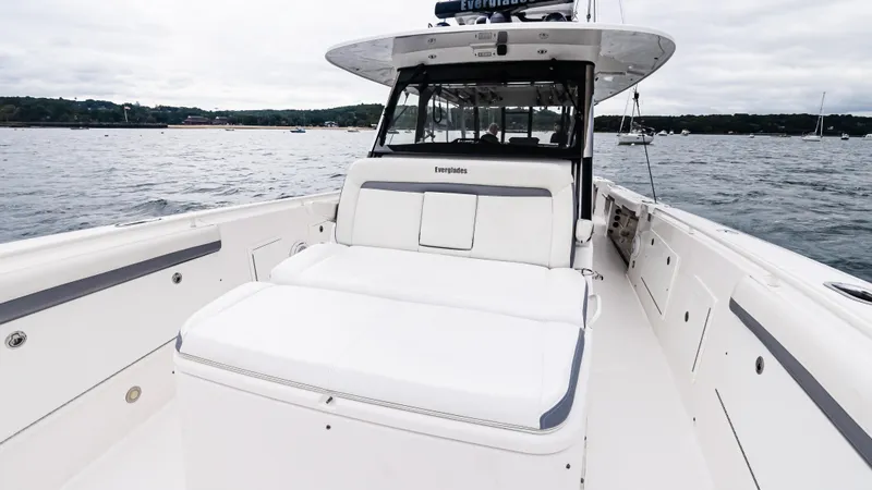 Slide: The Image of 2017 Everglades 435 CC boat on water, featuring spacious deck and seating. - 45