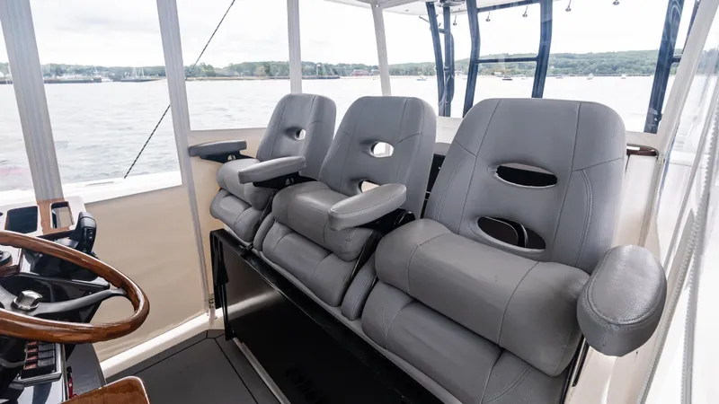 Slide: The Image of Three gray seats in the cockpit of a 2017 Everglades 435 CC boat. - 49