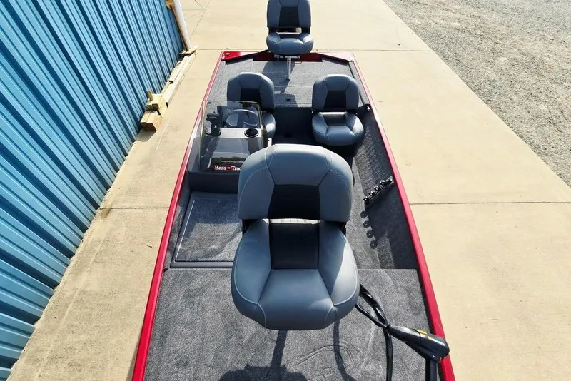 Slide: The Image of 2026 Tracker Bass Tracker Classic XL boat with gray seating and red trim, parked by a blue wall. - 28