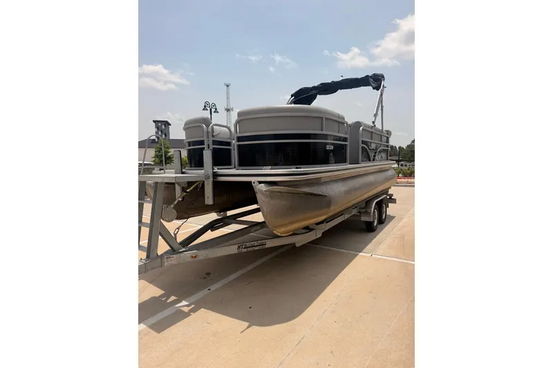 Slide: The Image of 2021 Lowe SS 210 pontoon boat on trailer under clear sky. - 1