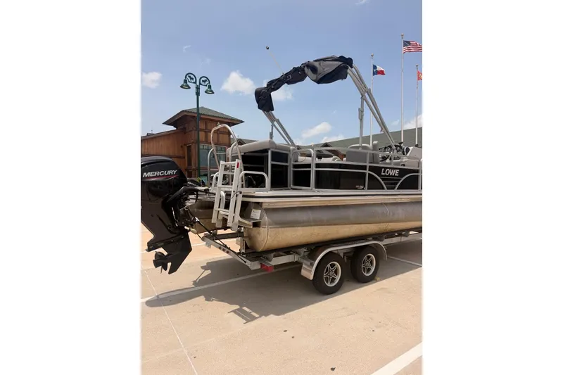 Slide: The Image of 2021 Lowe SS 210 pontoon boat on trailer with Mercury outboard motor. - 2