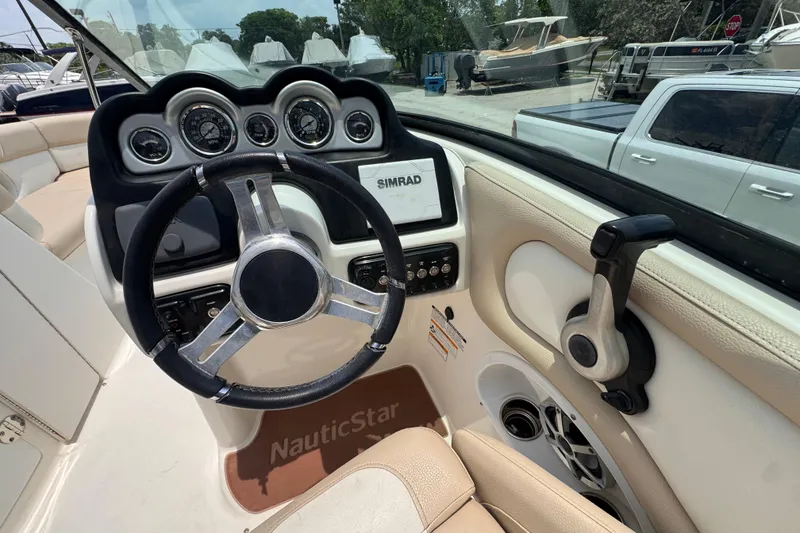Slide: The Image of 2018 NauticStar 243DC Sport Deck boat dashboard with steering wheel and controls. - 10