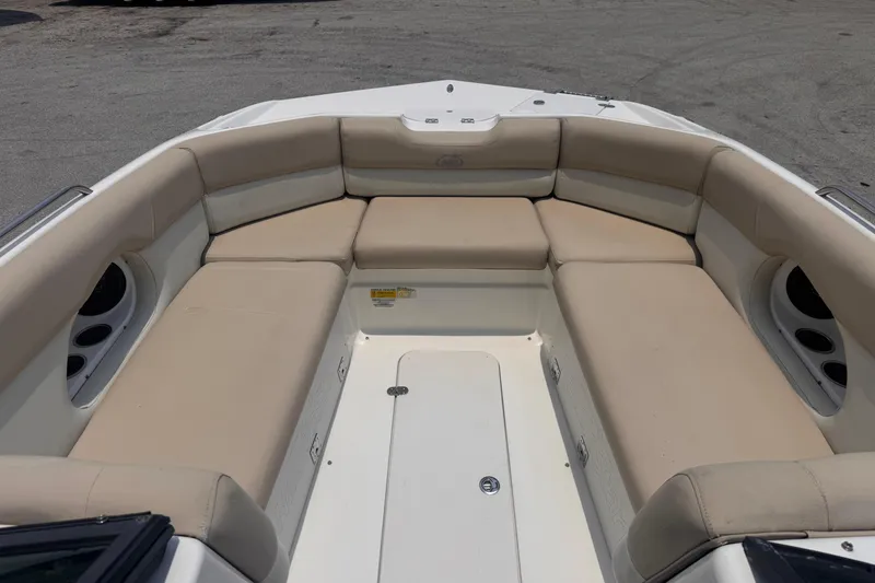 Slide: The Image of 2018 NauticStar 243DC Sport Deck boat with beige cushioned seating area. - 13