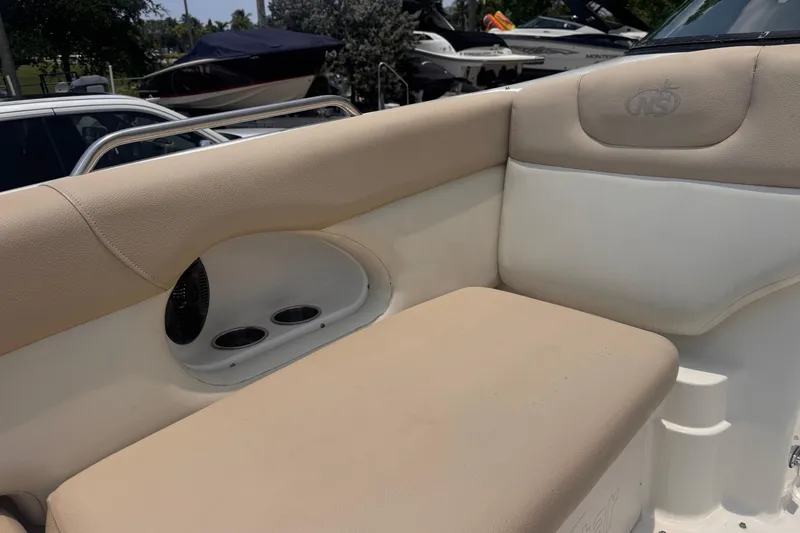 Slide: The Image of 2018 NauticStar 243DC Sport Deck boat interior with beige seating and cup holders. - 15