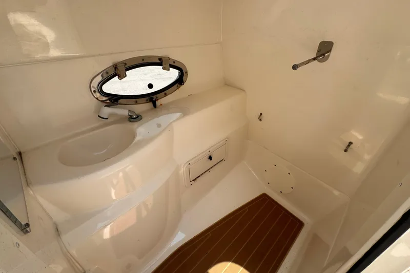 Slide: The Image of 2018 NauticStar 243DC Sport Deck interior with sink and porthole window. - 16