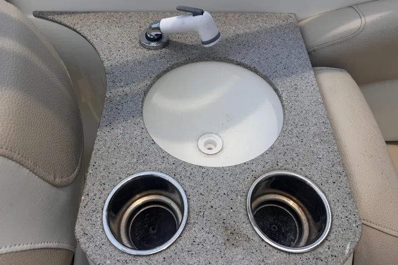 Slide: The Image of 2018 NauticStar 243DC Sport Deck boat sink with granite countertop and cup holders. - 17