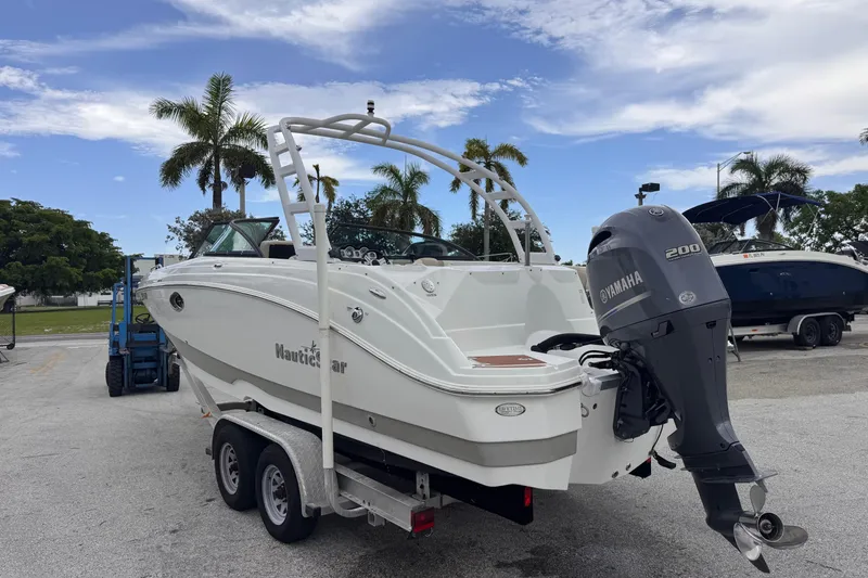 Slide: The Image of 2018 NauticStar 243DC Sport Deck boat with Yamaha 200 engine on trailer. - 5