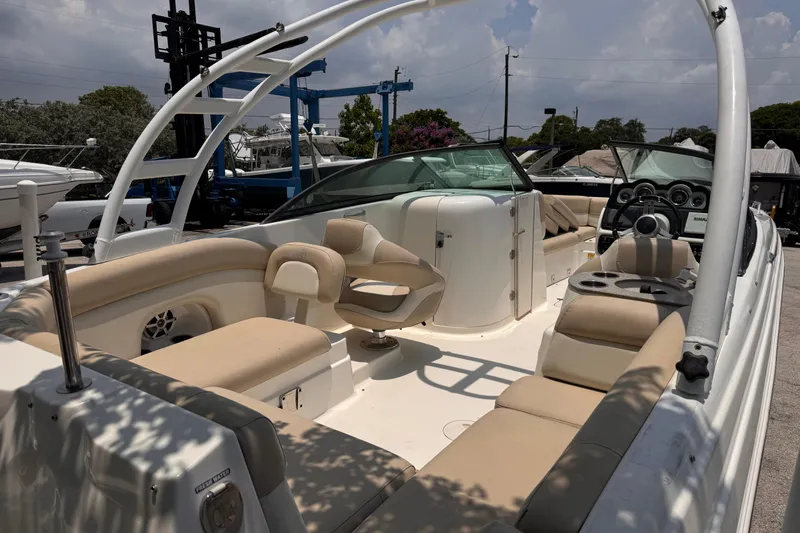 Slide: The Image of 2018 NauticStar 243DC Sport Deck boat with beige seating and modern dashboard. - 8