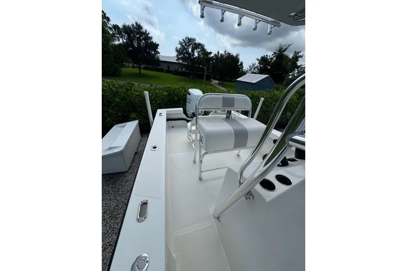 Slide: The Image of 2022 Rambo 27 boat interior with seating and rod holders, set against a lush green backdrop. - 11