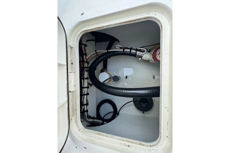 Slide: The Image of Interior view of a 2022 Rambo 27 boat compartment with hoses and wiring. - 12