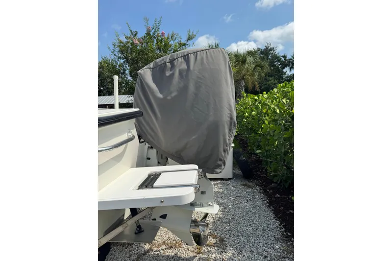 Slide: The Image of Covered outboard motor on a 2022 Rambo 27 boat, parked on gravel. - 16