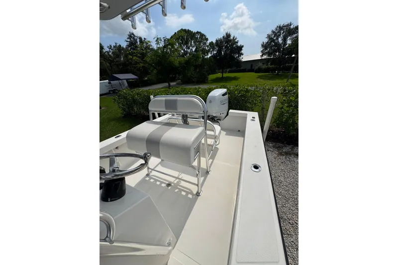 Slide: The Image of 2022 Rambo 27 boat interior with steering wheel and seating, parked outdoors. - 3