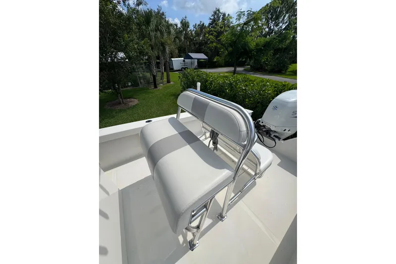 Slide: The Image of White seating on a 2022 Rambo 27 boat, surrounded by lush greenery. - 4
