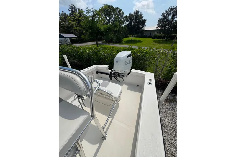 Slide: The Image of 2022 Rambo 27 boat with Suzuki outboard motor, parked outdoors on a sunny day. - 5