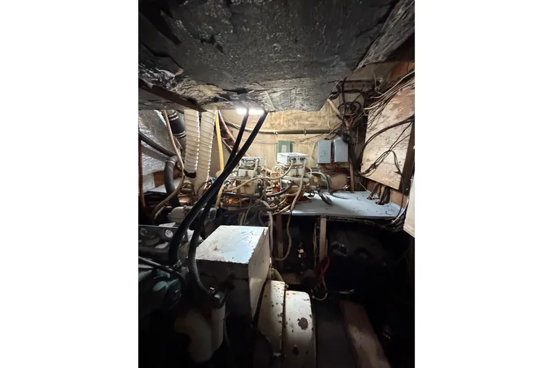 Slide: The Image of Engine room of a 1977 Morgan Out Island 51 sailboat, showing mechanical components and wiring. - 39