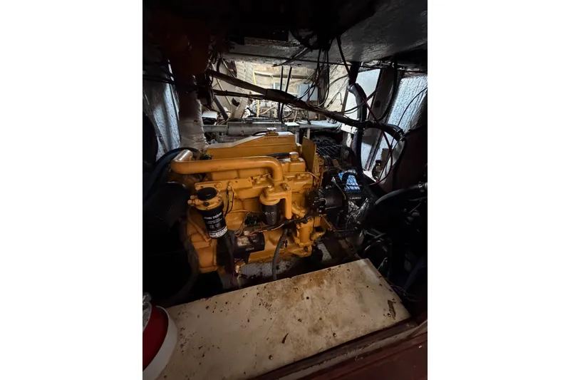 Slide: The Image of Engine room of a 1977 Morgan Out Island 51 sailboat, featuring a yellow engine. - 36
