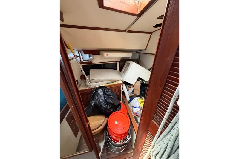 Slide: The Image of 1977 Morgan Out Island 51 interior cluttered with buckets, bags, and miscellaneous items. - 34