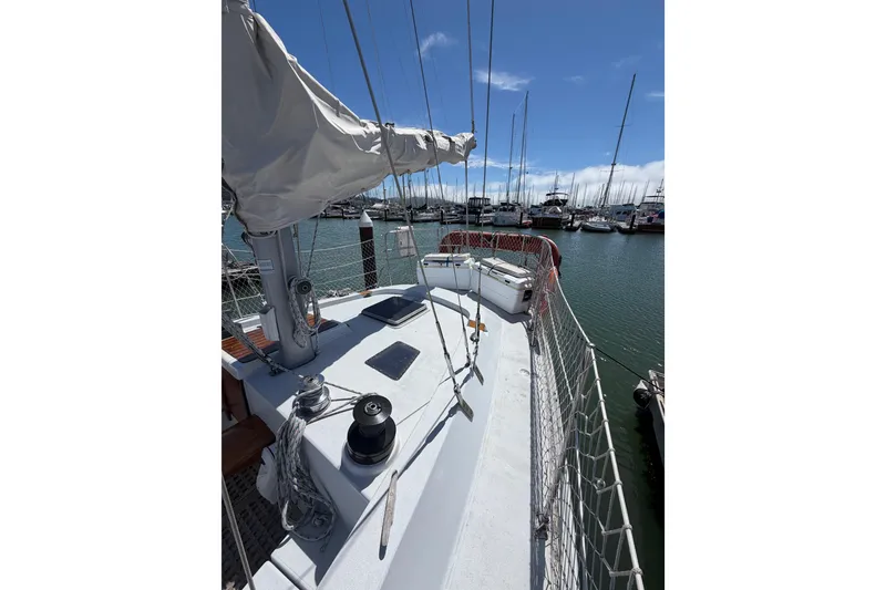 Slide: The Image of 1977 Morgan Out Island 51 sailboat docked in a marina under a clear blue sky. - 24
