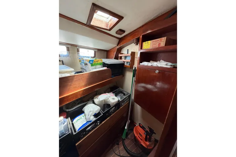 Slide: The Image of Interior of 1977 Morgan Out Island 51 sailboat with wooden cabinets and storage items. - 47