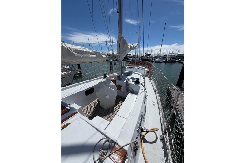 Slide: The Image of 1977 Morgan Out Island 51 sailboat docked in a marina under a clear blue sky. - 23