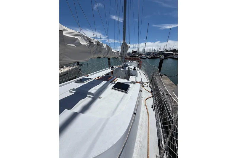 Slide: The Image of 1977 Morgan Out Island 51 sailboat docked at marina under clear blue sky. - 22