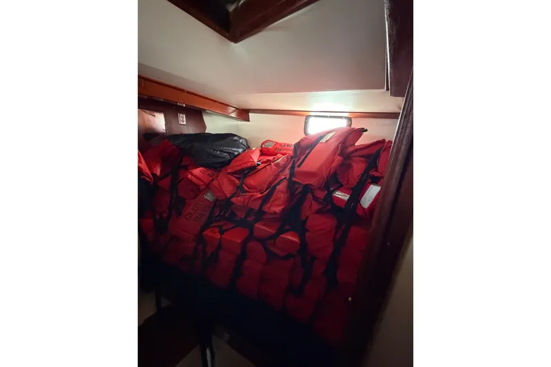 Slide: The Image of Stack of red life jackets inside a 1977 Morgan Out Island 51 sailboat cabin. - 49