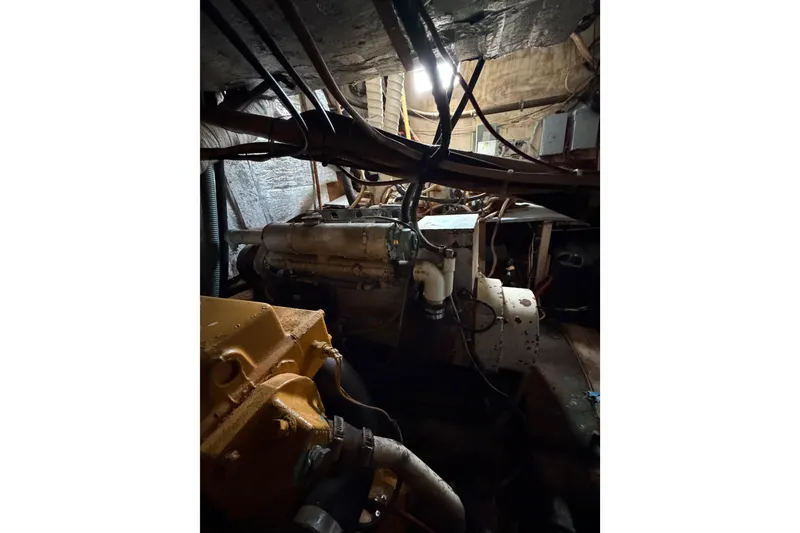 Slide: The Image of Engine room of a 1977 Morgan Out Island 51 sailboat, showcasing mechanical components. - 38