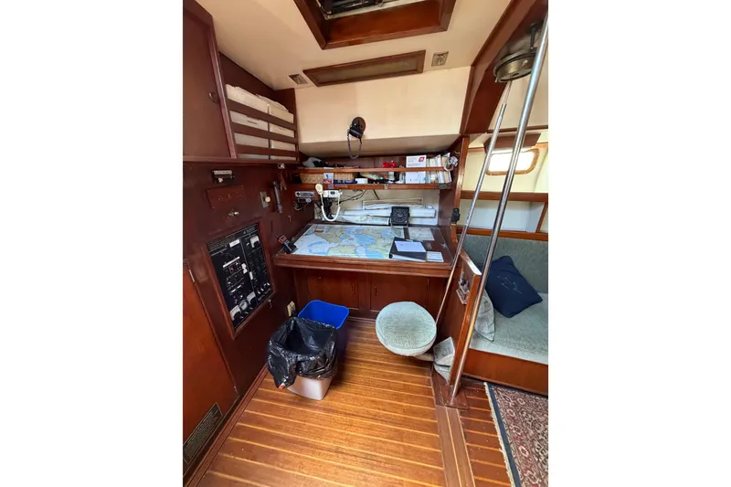 Slide: The Image of Navigation station inside a 1977 Morgan Out Island 51 sailboat, featuring charts and equipment. - 41