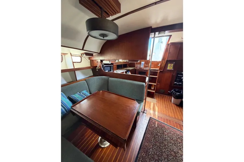 Slide: The Image of Interior of a 1977 Morgan Out Island 51 yacht with wooden furnishings and cozy seating area. - 50