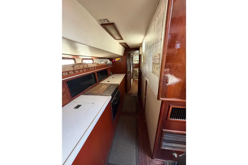 Slide: The Image of Interior view of 1977 Morgan Out Island 51 yacht, featuring a narrow galley with wood finishes. - 31