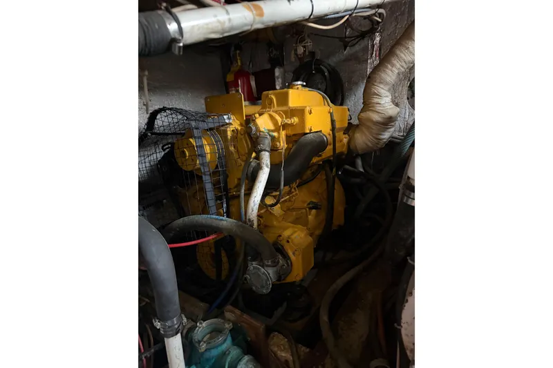 Slide: The Image of Engine compartment of a 1977 Morgan Out Island 51 sailboat, featuring a yellow engine. - 56