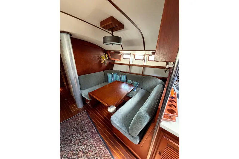 Slide: The Image of Cozy interior of 1977 Morgan Out Island 51 sailboat with wooden table and cushioned seating. - 43