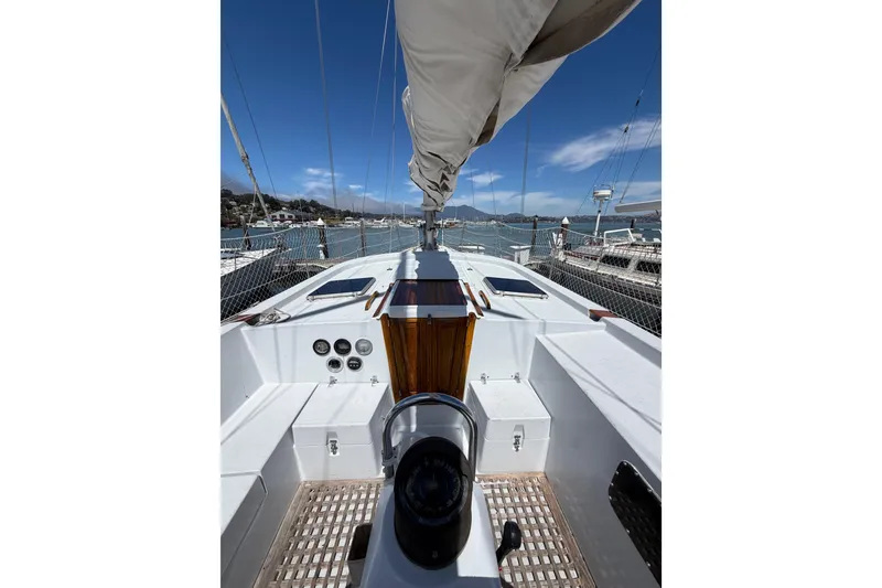 Slide: The Image of 1977 Morgan Out Island 51 sailboat deck with clear sky and marina view. - 27