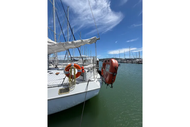Slide: The Image of 1977 Morgan Out Island 51 sailboat docked in marina under clear blue sky. - 60