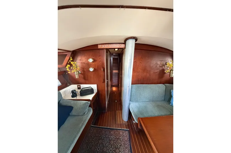 Slide: The Image of Interior of 1977 Morgan Out Island 51 yacht with wood paneling and cozy seating area. - 44