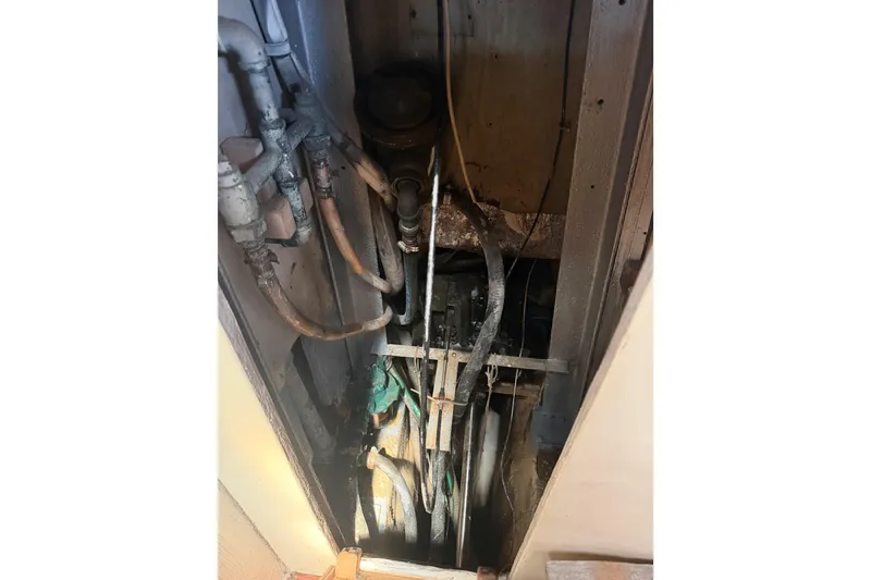 Slide: The Image of Engine compartment of a 1977 Morgan Out Island 51 sailboat, showing pipes and mechanical components. - 35