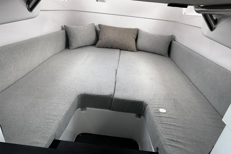 Slide: The Image of 2024 Axopar 37 XC Cross Cabin interior with gray cushioned seating and pillows. - 14