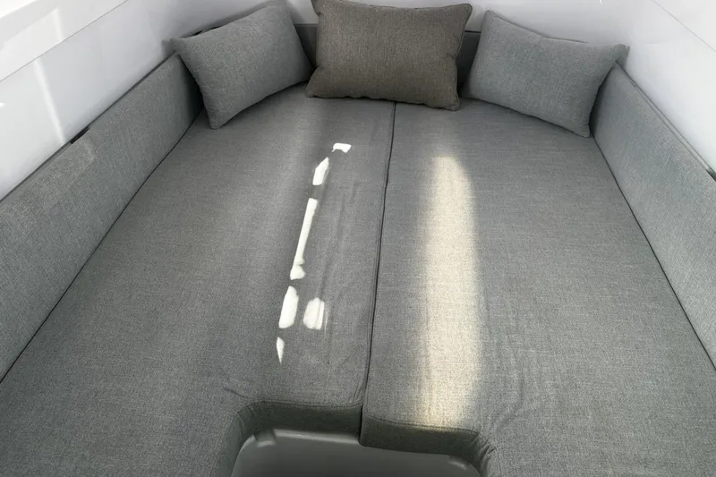 Slide: The Image of 2024 Axopar 37 XC Cross Cabin interior with gray cushioned seating and pillows. - 12