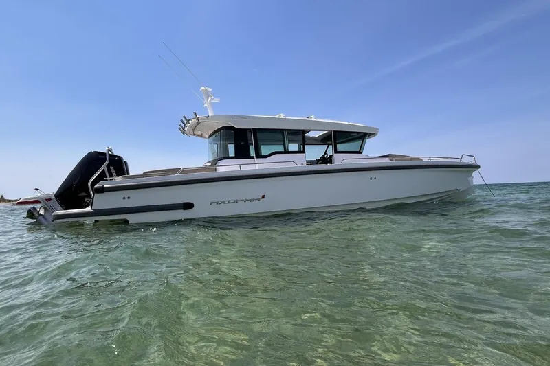 Slide: The Image of 2024 Axopar 37 XC Cross Cabin boat on clear water under blue sky. - 4