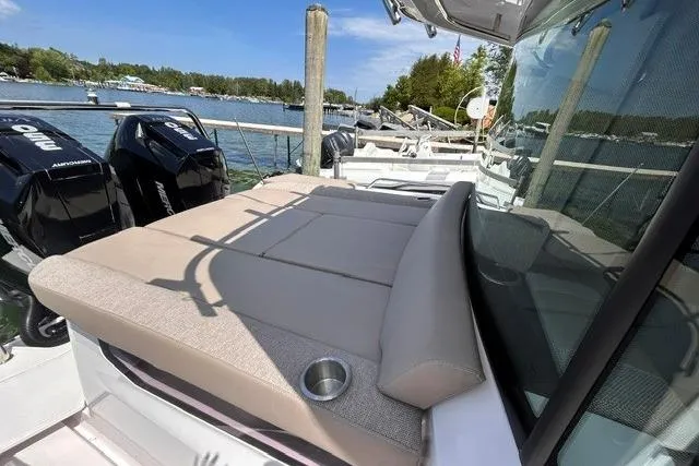 Slide: The Image of 2024 Axopar 37 XC Cross Cabin with sunbed and twin outboard engines docked by the water. - 18