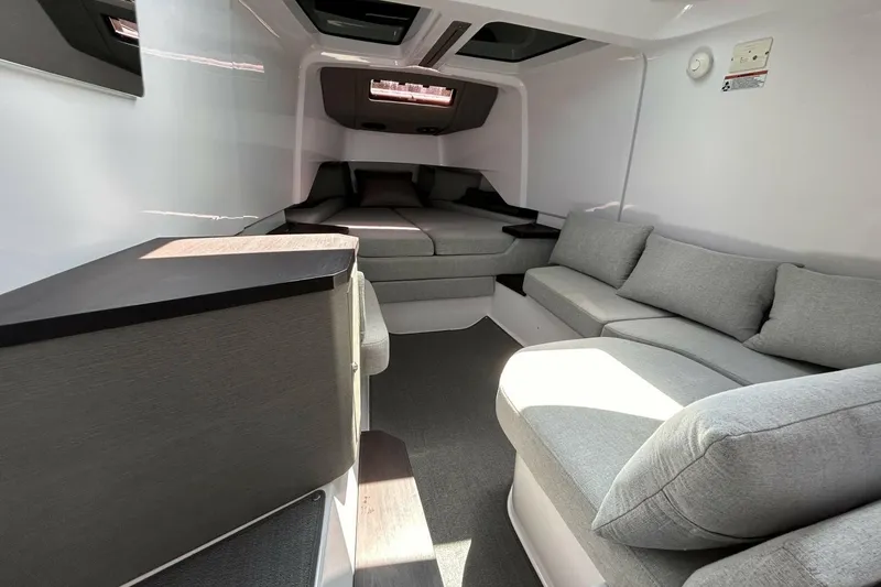 Slide: The Image of 2024 Axopar 37 XC Cross Cabin interior with modern seating and cozy sleeping area. - 8