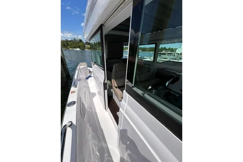 Slide: The Image of 2024 Axopar 37 XC Cross Cabin boat docked, showcasing sleek design and spacious interior. - 19