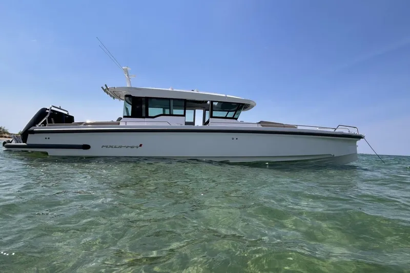 Slide: The Image of 2024 Axopar 37 XC Cross Cabin boat on clear water under blue sky. - 3