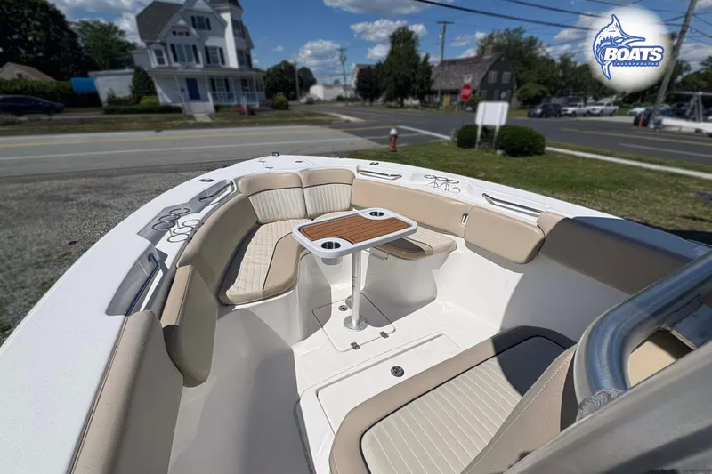 Slide: The Image of 2015 Sea Fox 266 Commander boat interior with seating and table, parked near a road. - 3